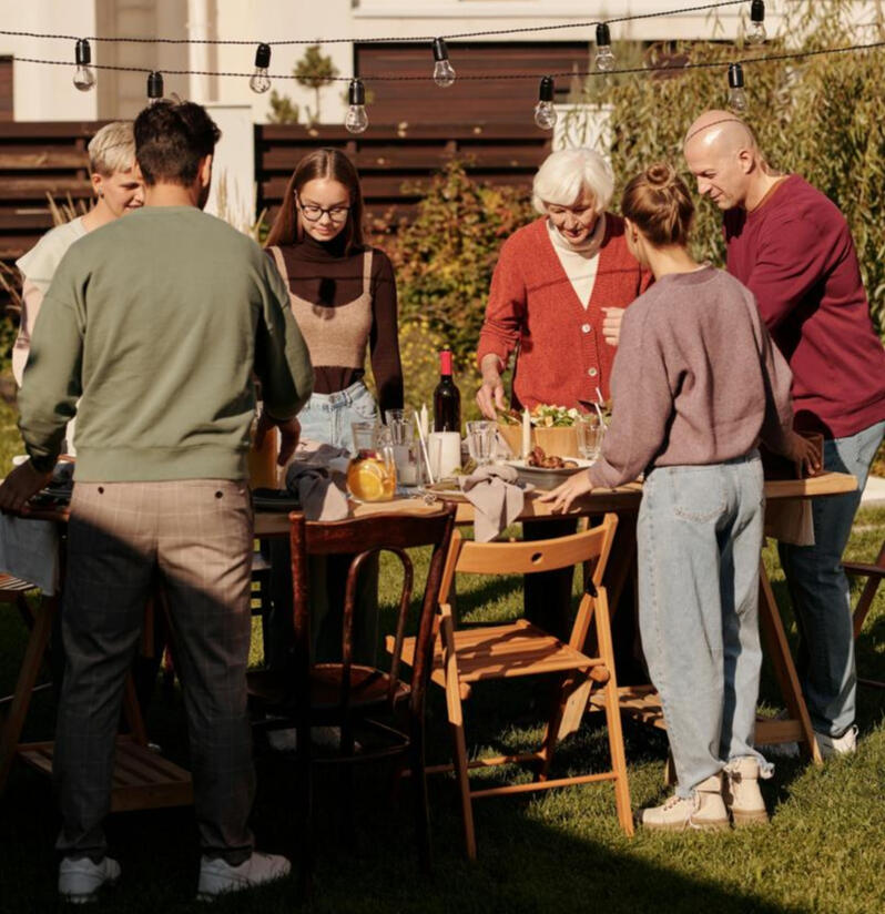 Residents gathered for a shared meal at a Resident Roots community event Group of apartment residents of all ages enjoying an outdoor meal together during a Resident Roots-hosted event